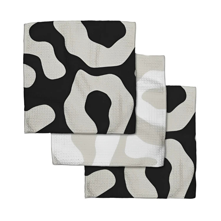 This set of a 3 pack modern dishcloths in a 'Mixed Up' print, featuring a stylish mix of black, white, and tan. These dishcloths add a sleek, contemporary touch to your kitchen with bold geometric patterns. Made from highly absorbent fabric, they’re perfect for everyday dishwashing, cleaning, or wiping down surfaces while enhancing your home’s minimalist aesthetic.