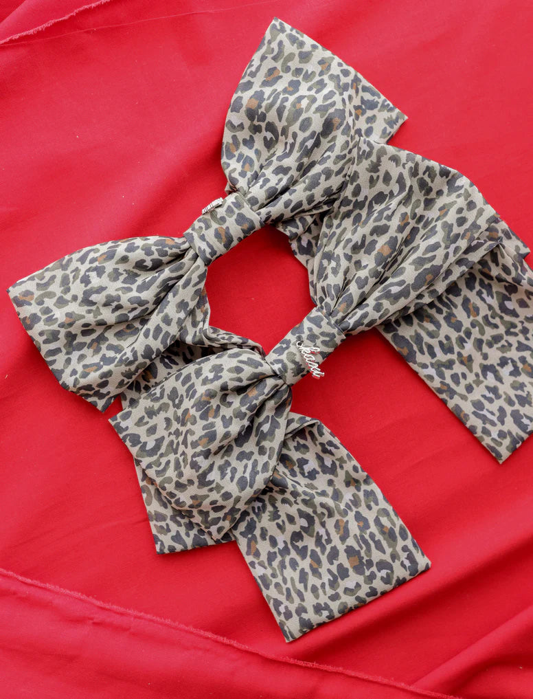 The KAXI Slouchy Cheetah Bow – Stylish and comfortable oversized bow with a trendy cheetah print, perfect for effortless chic hairstyles and statement looks. It has a barrette style clip and a stylish "kaxi" branded charm. Such a stunning accessory to your fashion.